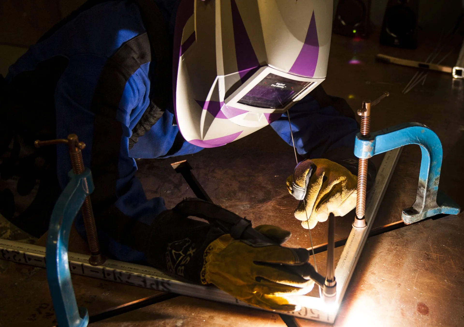 Lasser verbindt een geklemd metalen kader aan de werkbank