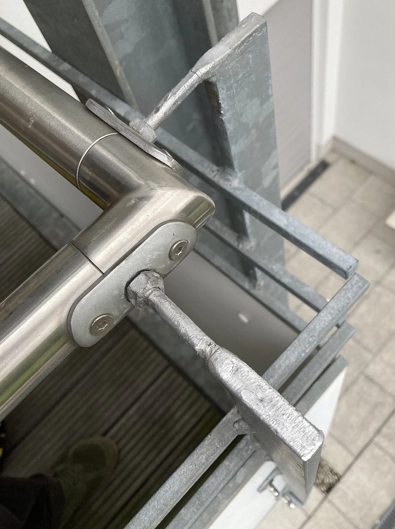 Inox handgreep met koppelstuk op een verzinkte metalen balkonsteun