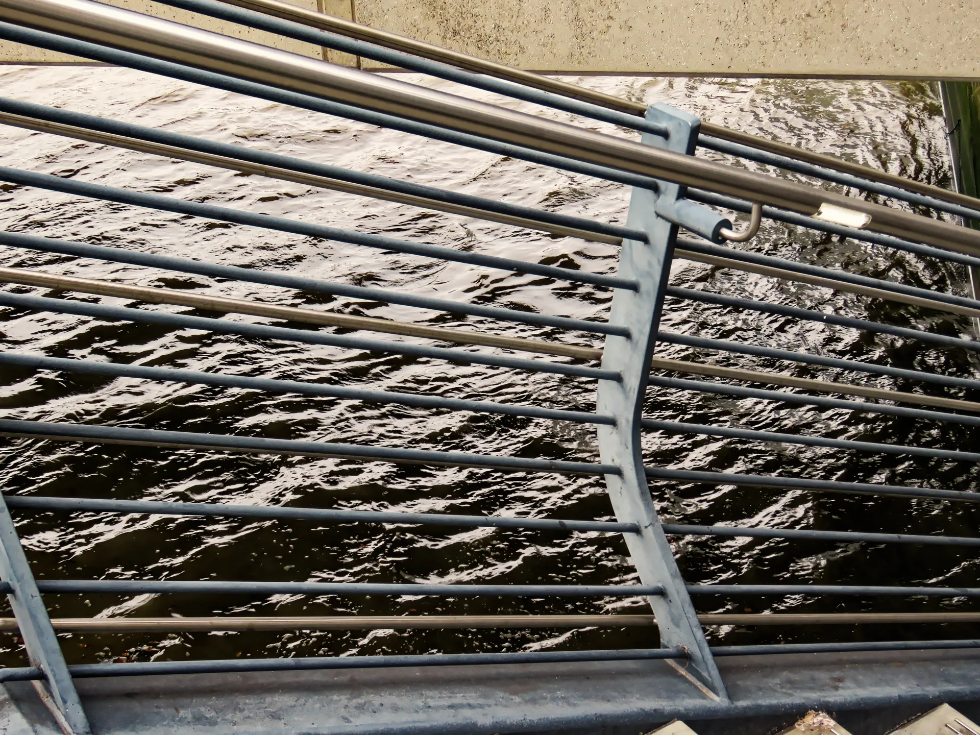 Inox handgreep boven een geschilderde metalen balustrade bij London Bridge