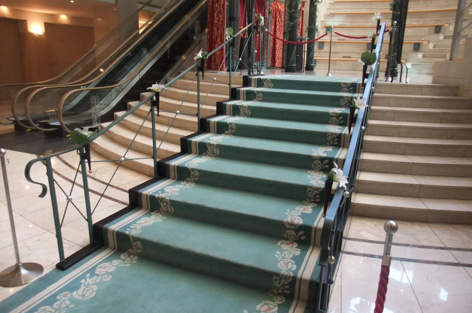 Donkergroene ijzeren trapbalustrade met gekruiste spijlen langs een binnentrap